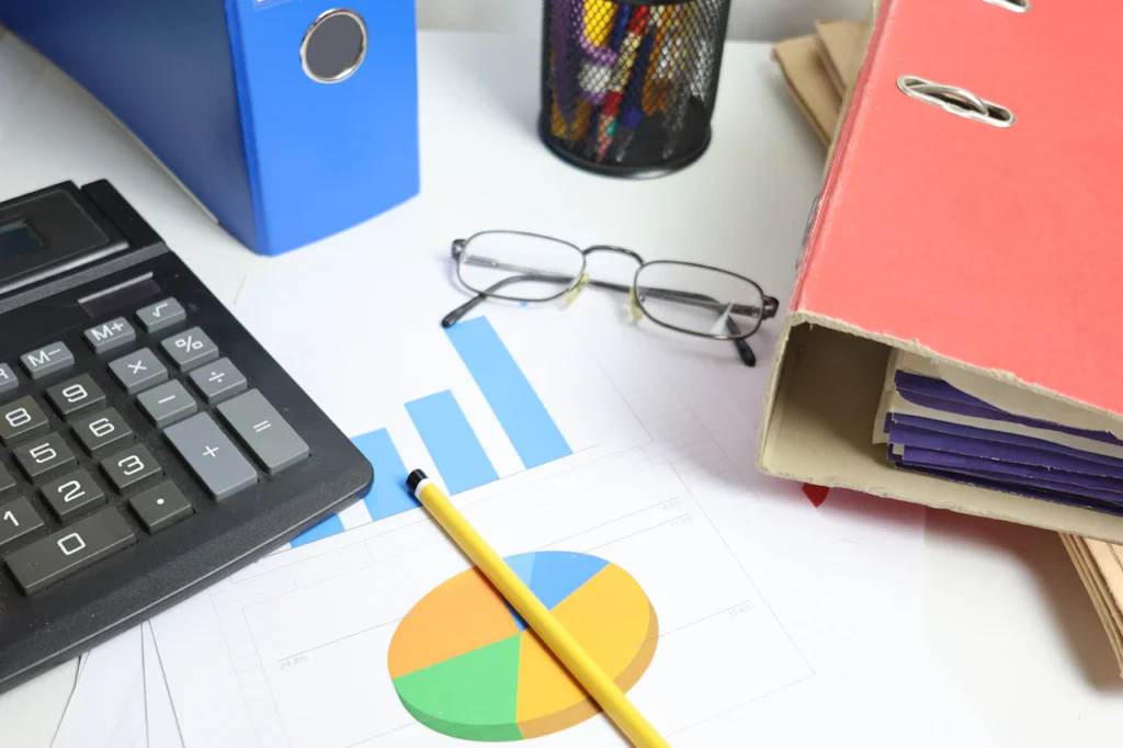 Calculator, financial charts and organised paperwork on a desk